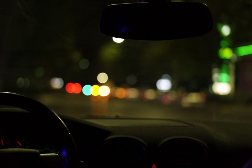 Practice Areas Blurred city lights seen from a car interior at night, depicting urban driving ambiance.